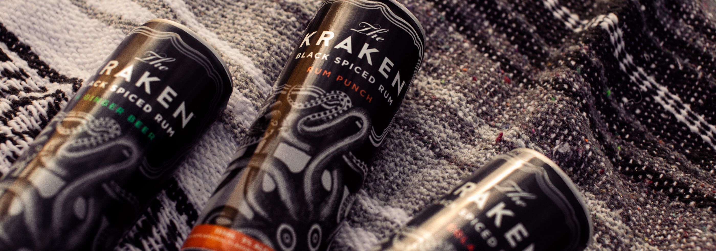 The Kraken Canned Cocktails on a picnic blanket